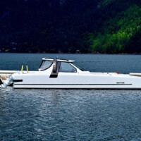 A sleek white motorboat docked at a pier in Cowichan Bay.